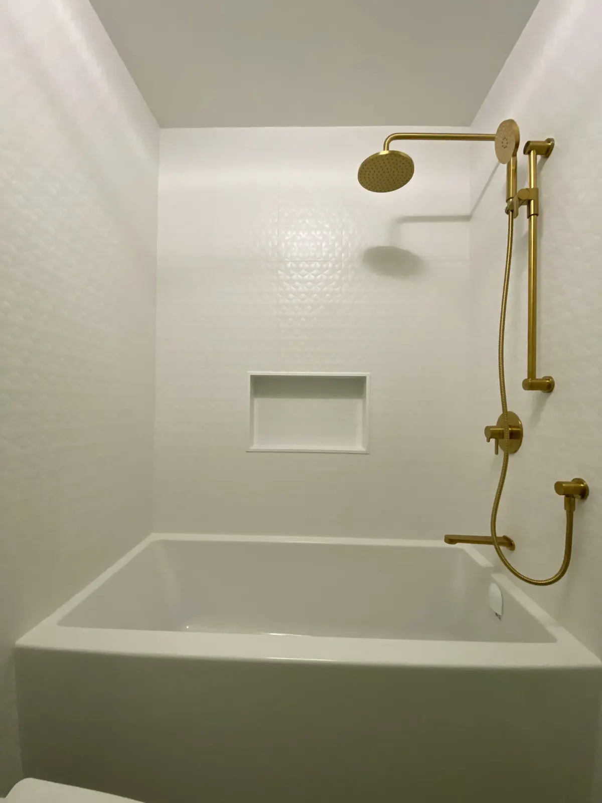 Alcove tub with brushed gold shower set