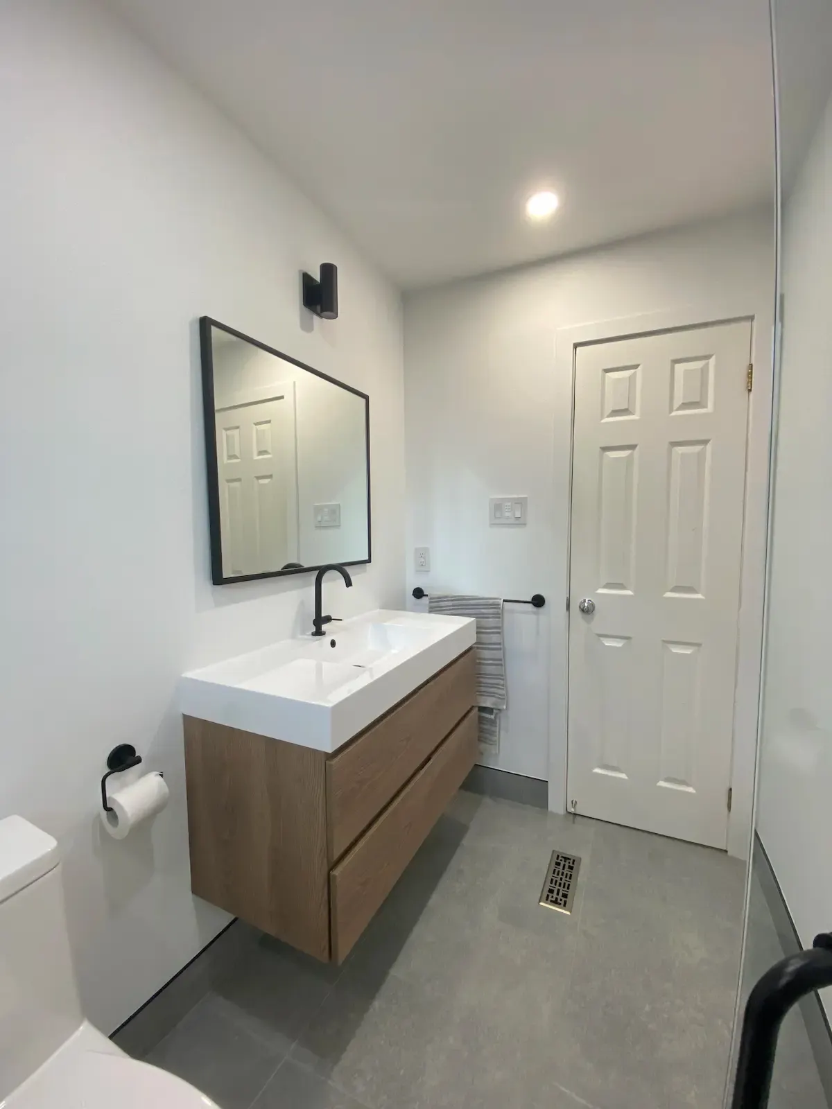 Guest bathroom with oak vanity and black framed mirror